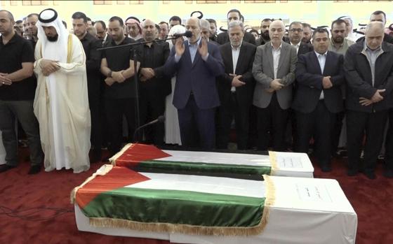 This video grab shows senior Hamas official Khalil al-Hayya, center, praying near the coffin of Hamas leader Ismail Haniyeh and his bodyguard during the funeral prayers in Doha, Qatar, Friday Aug. 2, 2024. 