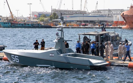 U.S. and Emirati forces survey the Arabian Fox Mast-13 drone boat Oct. 14, 2024, during exercise Iron Defender in the United Arab Emirates. Unmanned vessels were a focus of the 10-day bilateral exercise, which ended Thursday.