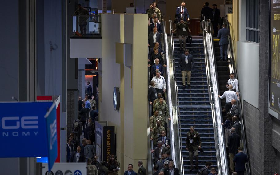 Attendees descend into the exhibit area on an escalator