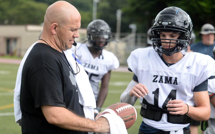 Eighth-year Zama head coach Scott Bolin talks things over with William Schmiedel, one of two sophomore quarterbacks vying for the starting job.