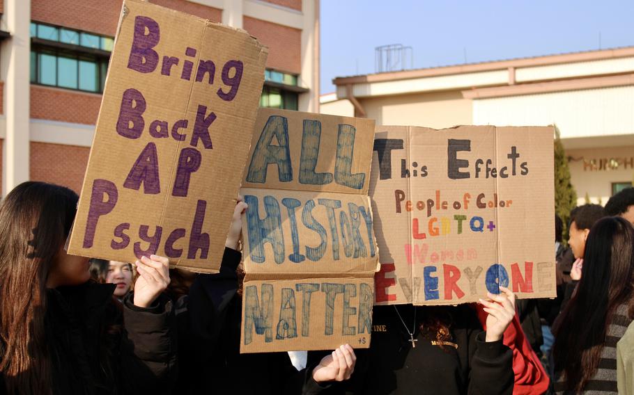 Students hold up protest signs