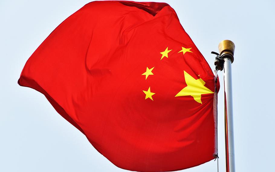 A Chinese flag hangs from a pole.