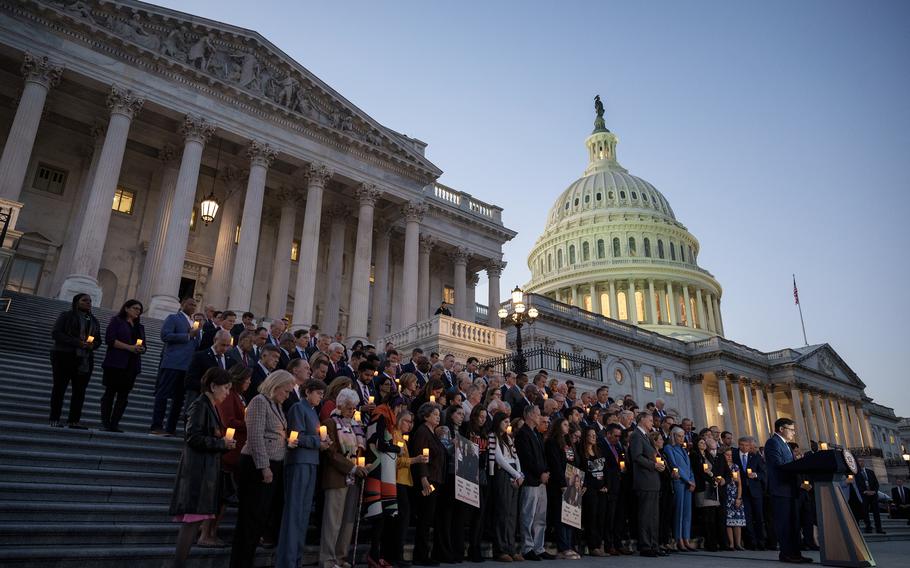 At right, U.S Speaker of the House Mike Johnson (R-LA) bows his head while delivering a prayer during a bipartisan candlelight vigil with members of Congress to commemorate one month since the Hamas terrorist attacks in Israel on Oct. 7, at the U.S. Capitol Nov. 7, 2023, in Washington.