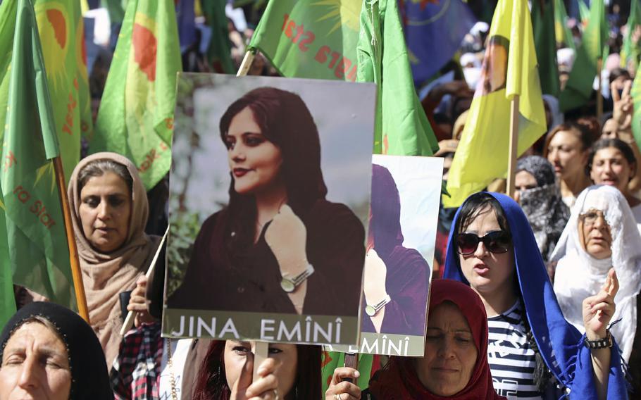 Protesters in Syria hold a portrait of Mahsa Amini in September 2022