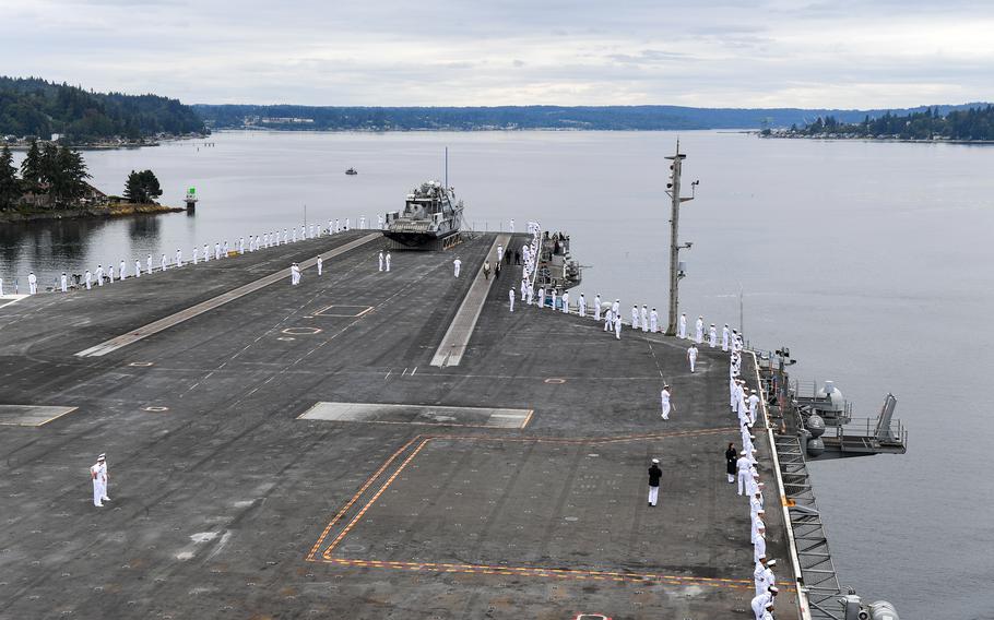 Sailors from the USS Ronald Reagan man the railing as the aircraft carrier arrives at its new homeport, Naval Station Kitsap in Bremerton, Washington, on August 13, 2024. 