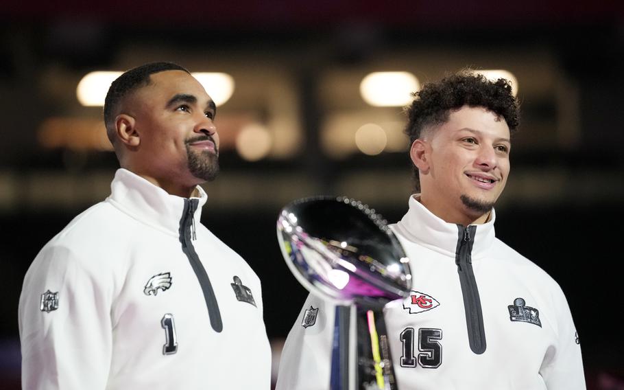 Philadelphia Eagles quarterback Jalen Hurts (1) and Kansas City Chiefs quarterback Patrick Mahomes (15) pose with the trophy during Super Bowl 59 