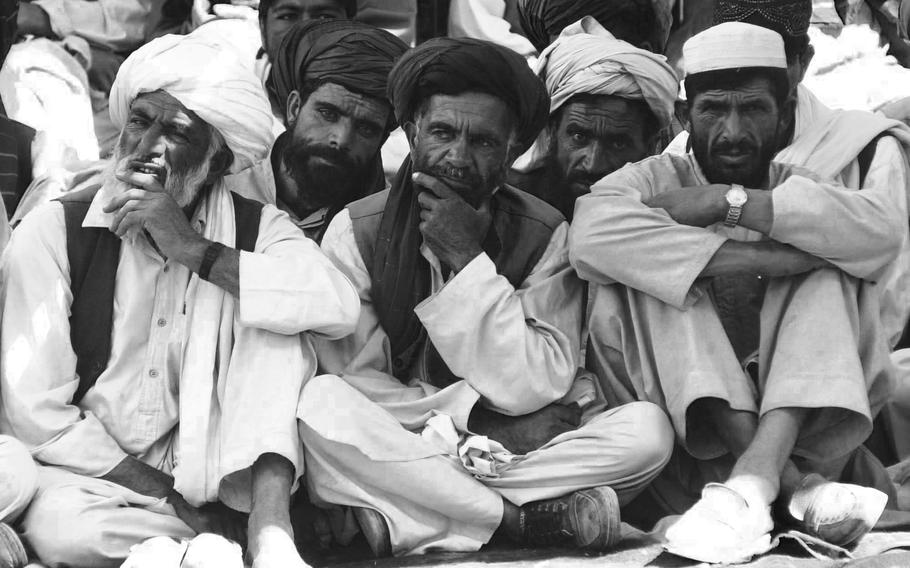 Local men listen during a meeting