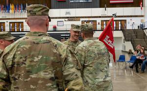 U.S. Army Capt. Ricky Kuhn, 817th Engineer Company, Sapper, outgoing commander, left, watches as Lt. Col. Steven Bohl, 164th Engineer Battalion commander, passes the 817th Engineer Company, Sapper, guidon to his older brother, Capt. Toby Kuhn, signifying the relinquishing of command, during the change of command ceremony in Jamestown, North Dakota, Jan. 12, 2025. The brothers enlisted into the U.S. Army at different times, but both commissioned in 2017. (U.S. National Guard photo by Spc. Anna Welchel)