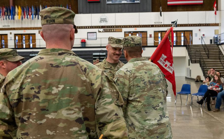 U.S. Army Capt. Ricky Kuhn watches as Lt. Col. Steven Bohl passes the 817th Engineer Company, Sapper, guidon to his older brother, Capt. Toby Kuhn