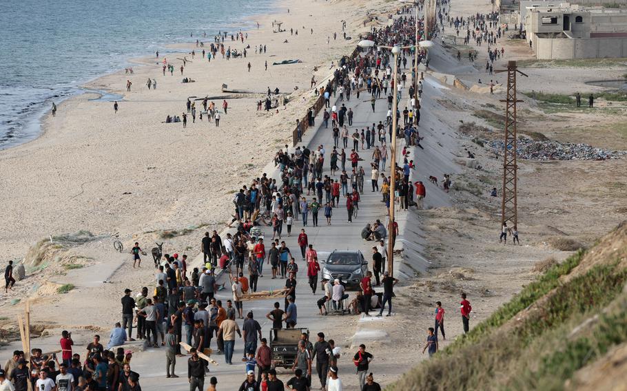 Palestinians gather May 19, 2024, in the hope of obtaining aid delivered into Gaza through a U.S.-built pier amid the ongoing conflict between Israel and Hamas. 