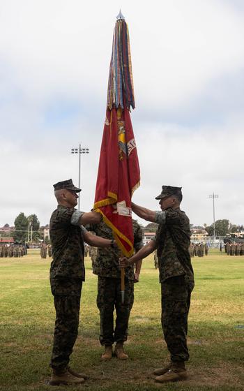 U.S. Marine Corps Maj. Gen. Benjamin T. Watson, right, the outgoing commanding general of 1st Marine Division, passes the division colors to Maj. Gen. Robert C. Fulford, the incoming commanding general of 1st MARDIV, during the division’s change of command ceremony at Marine Corps Base Camp Pendleton, Calif., July 2, 2024. 