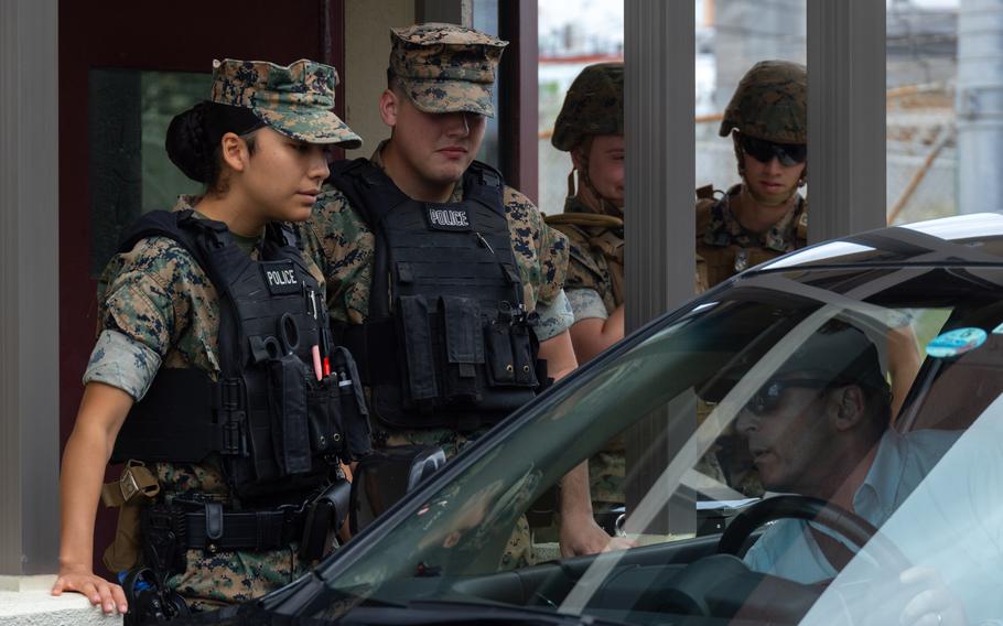 Marine Lance Cpls. Alize Reyes, left, and Austin Walker, check IDs at Marine Corps Air Station Futenma, Okinawa, Japan, March 27, 2024. Sobriety checks are scheduled at all Marine bases in Japan on July 12 and 13, 2024.