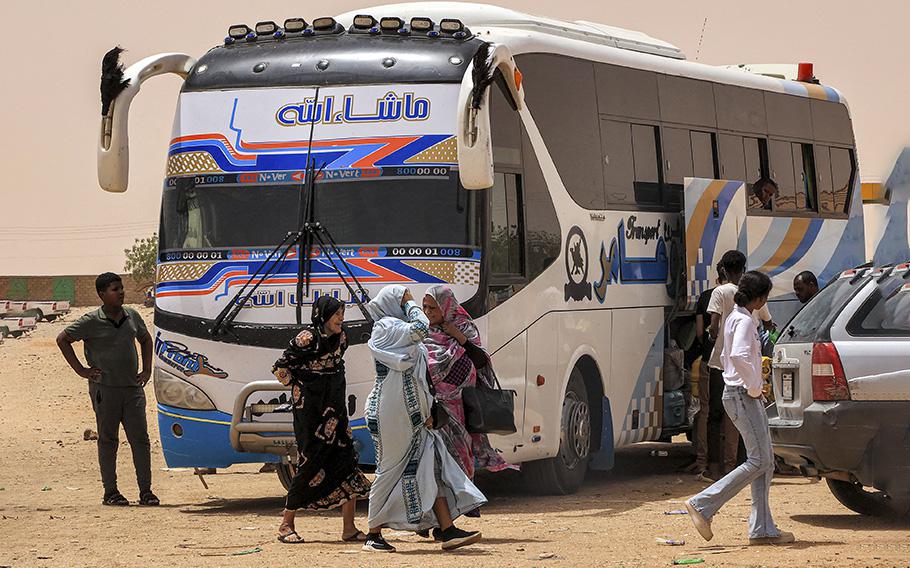 People disembark off a passenger bus at the Multaga rest-stop near Ganetti in Sudan’s Northern State on April 25, 2023, about 300 kilometres northwest of the capital, on April 25, 2023. Ten days of heavy fighting between the Sudanese army and paramilitaries, including air strikes and artillery barrages, have killed hundreds of people, many of them civilians, and left some neighborhoods of the capital in ruins.