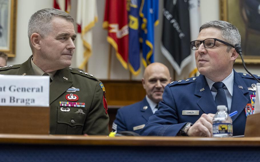 Two men in uniforms seated at a table chatting.