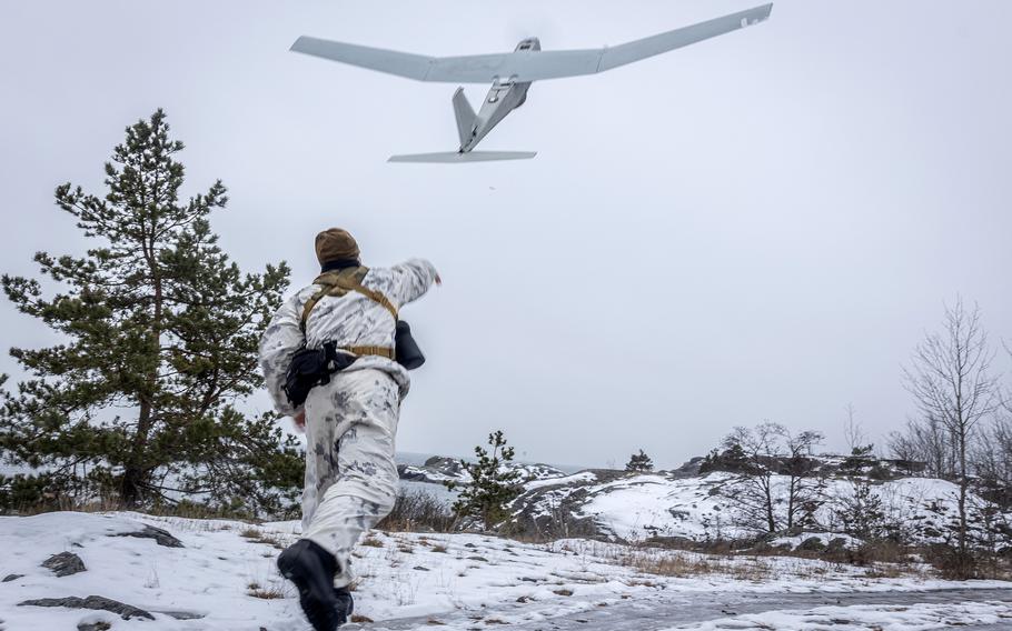 A special operations independent duty Navy corpsman launches an RQ-20 Puma aerial drone