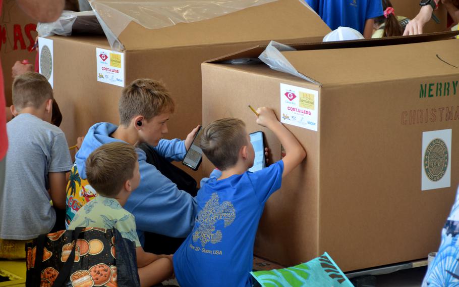 Scouts from  Troop 20 decorate a box for Operation Christmas Drop at Andersen Air Force Base, Guam.