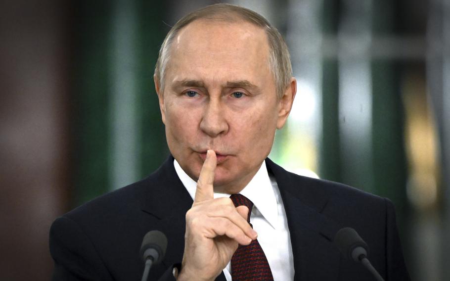 Vladimir Putin gestures while speaking.