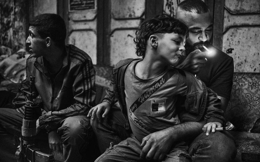 Zoufi, the commander of the al-Aqsa Martyrs Brigades, the military faction of the Fatah party that is designated a terrorist organization by the United States and others, sits with his son in the Balata refugee camp in the West Bank on Oct. 17, 2023. 