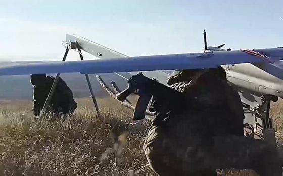 In this photo taken from video distributed by Russian Defense Ministry Press Service on Sunday, Jan. 26, 2025, Russian servicemen prepare a "Orlan-10" drone in an undisclosed location in Ukraine. (Russian Defense Ministry Press Service via AP)