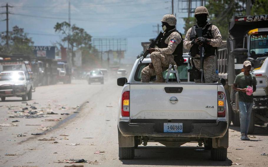 Haiti police on patrol keep their eyes on traffic during a stop at a police checkpoint in Tabarre, near the U.S. embassy, just east of metropolitan Port-au-Prince. Gangs have taken control of neighborhoods in the vicinity.