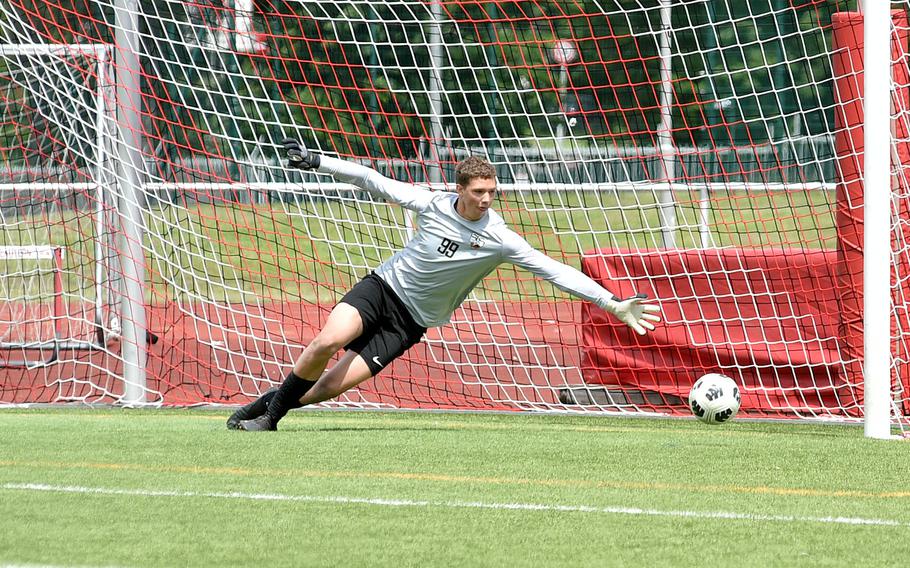 Stuttgart goalkeeper Caleb Fox dives after a free kick from Ramstein senior Maxim Speed that found the back of the net in a Division I semifinal of the DODEA European soccer championships May 22, 2024, at Kaiserslautern High School in Kaiserslautern, Germany.