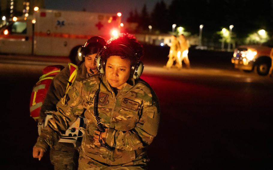 Air Force medics prepare to board a UH-1N Iroquois, or Huey, helicopter during a patient transport drill at Yokota Air Base, Japan, Dec. 18, 2023. 