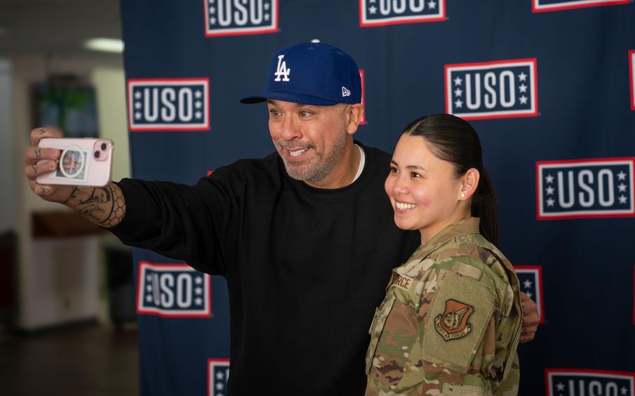 Jo Koy takes a selfie  with an airman