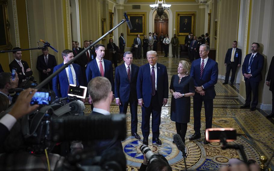 President-elect Donald Trump speaking to reporters with some allies standing next to him.