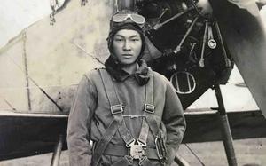 A Japanese soldier wearing a flight suit stands in front of a bomber in 1941.