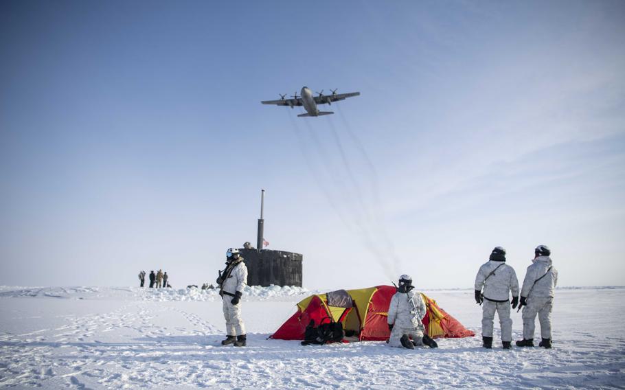 A C-130 Hercules assigned to the 109th Airlift Wing, part of the New York Air National Guard, flies over Navy SEALs, Norwegian naval special operations commandos and the attack submarine USS Hampton during an integration exercise in the Arctic Ocean on March 9, 2024. 