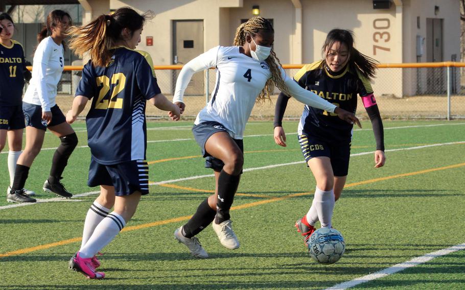 Osan’s Tatiana Lunn dribbles between two Cheongna Dalton defenders during Friday’s Korea girls soccer match. Lunn scored a hat trick and the Cougars won 4-0.