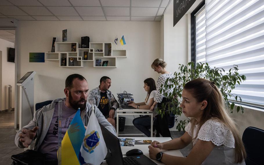 Civilian Oleksii, 34, left, talks to a recruitment agent in Dnipro, Ukraine. 