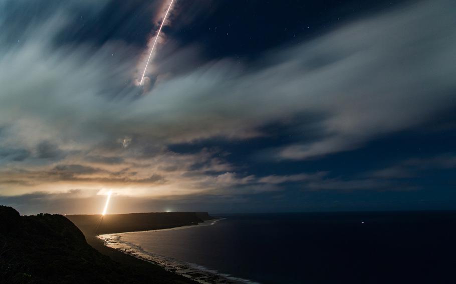 A missile interceptor streaks across the sky over a coastal area.