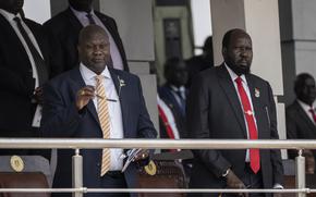 Two men in suits, one with a white and yellow tie and the other with a red tie.