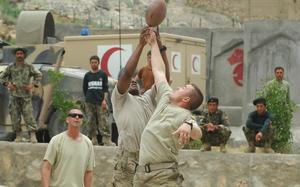 Nangalam Base, Afghanistan, July 28, 2011: Soldiers of Headquarters and Headquarters Company, 2nd Battalion, 35th Infantry Regiment, let off a little steam in between missions on the Pech River valley in Afghanistan on Thursday. Spc. Christopher Ramos, right, and Sgt. Timothy Stephens leap for a pass while Chaplain (Capt.) Jonathan Smith watches. The soldiers' activities got a lot of attention from Afghan soldiers at Nangalam Base.

META DATA:  Operation Enduring Freedom; Wars on Terror; taliban; Afghanistan; U.S. Army;  2nd Battalion, 35th Infantry Regiment; R&R