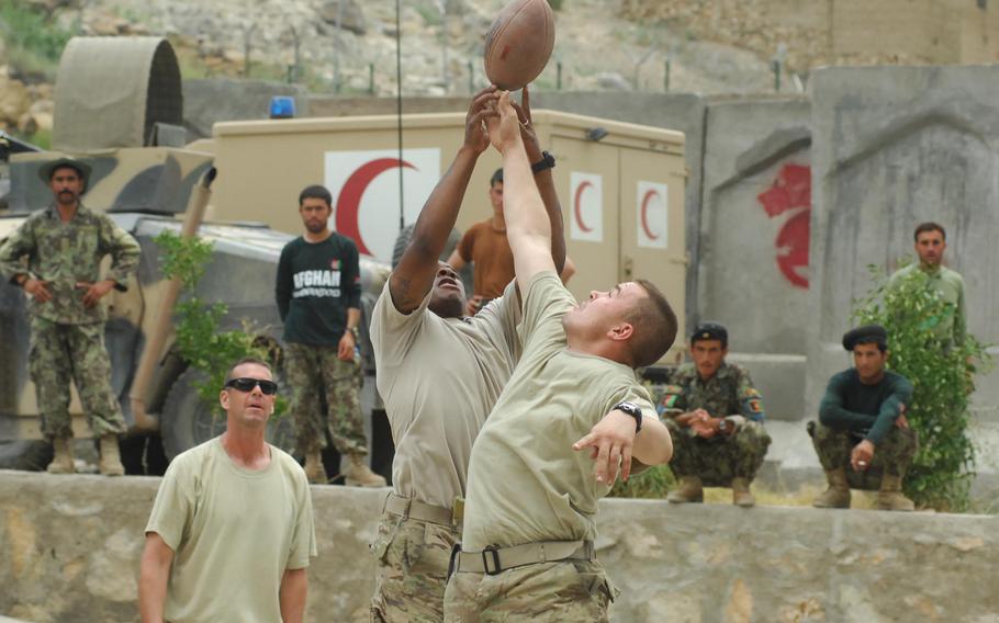 Army soldiers play football in Afghanistan