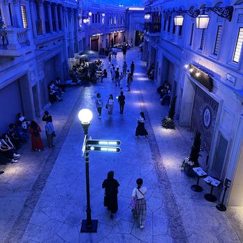 Overhead view of pedestrians walking on a fabricated street inside a shopping mall.