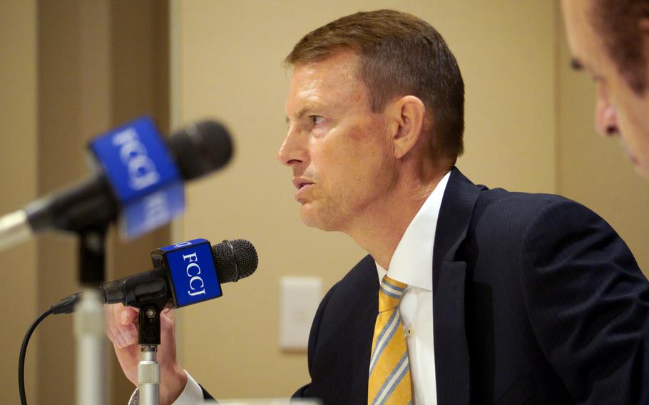 Retired U.S. Navy rear admiral Mike Studeman speaks in front of a microphone.