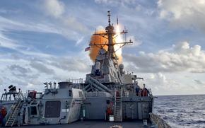 A destroyer launches a missile into the water.