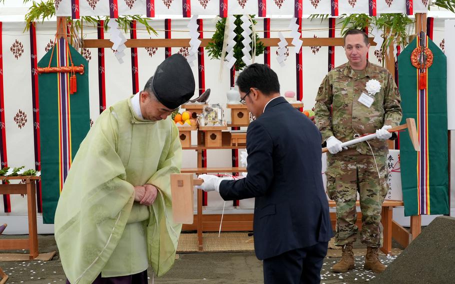 Ruel Binonwangan, Honshu area engineer for the U.S. Army Corps of Engineers’ Japan Engineer District, accepts a ceremonial digging tool from a Shinto priest at Yokota Air Base, Japan, June 22, 2023. The ceremony was part of the ground-breaking for a CV-22 Osprey hangar and maintenance facility. 