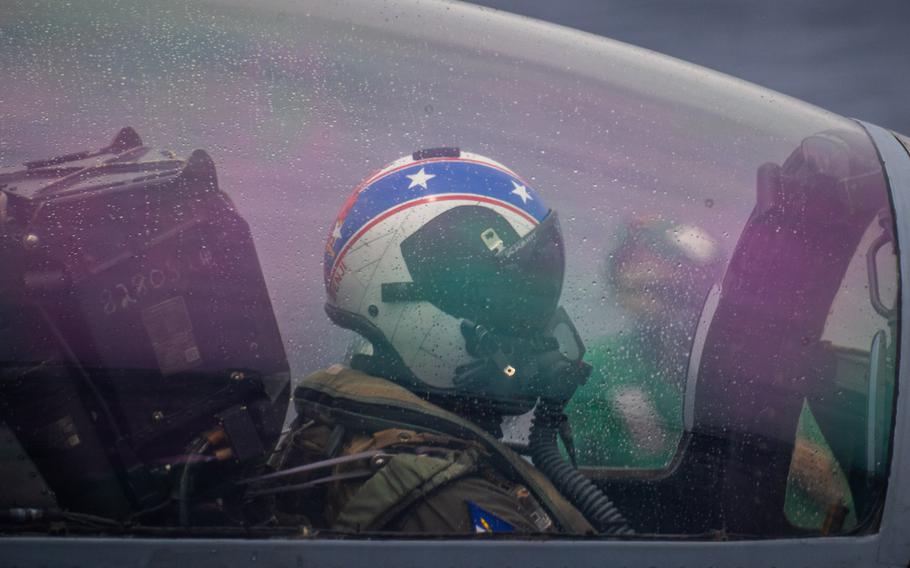 A helmeted pilot seen inside a jet canopy.