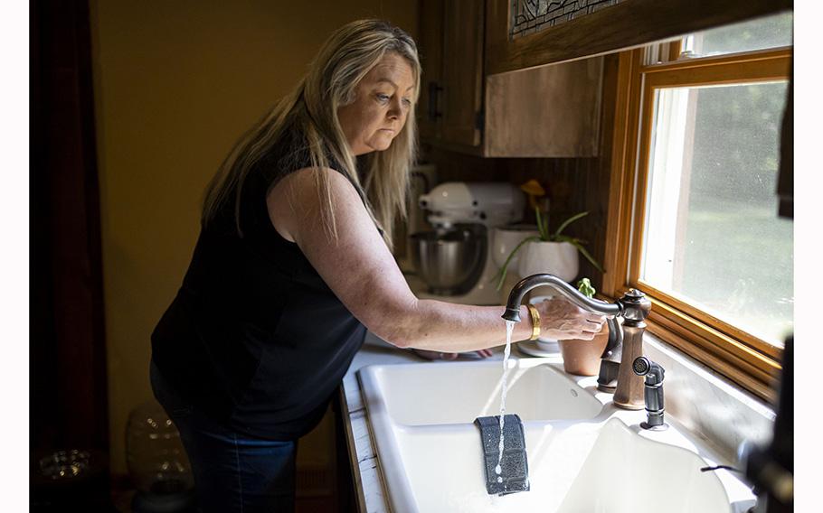 Kacy Krause turns on the faucet in her Rockton home, June 22, 2023. The Krauses, who live near the site of the 2021 Chemtool factory fire, now drink only bottled water after testing of their well water found toxic chemicals. 