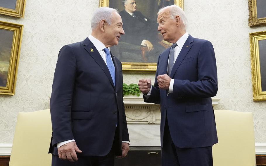 Joe Biden and Benjamin Netanyahu speak in front of portraits of former US presidents in the Oval Office of the White House.