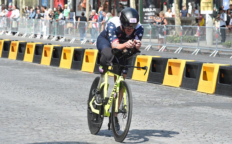 Marine veteran Eric McElvenny rides his bike along the famous Champs-Elysees during the men's PTS4 triathlon on Monday, Sept. 2, 2024, at the 2024 Paralympic Games in Paris. A former Marine captain, McElvenny competed in his second Paralympics.