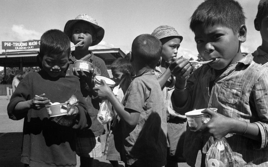 The children enjoy some ice cream in dixie cups that were passed out to them during a visit from Santa Claus.