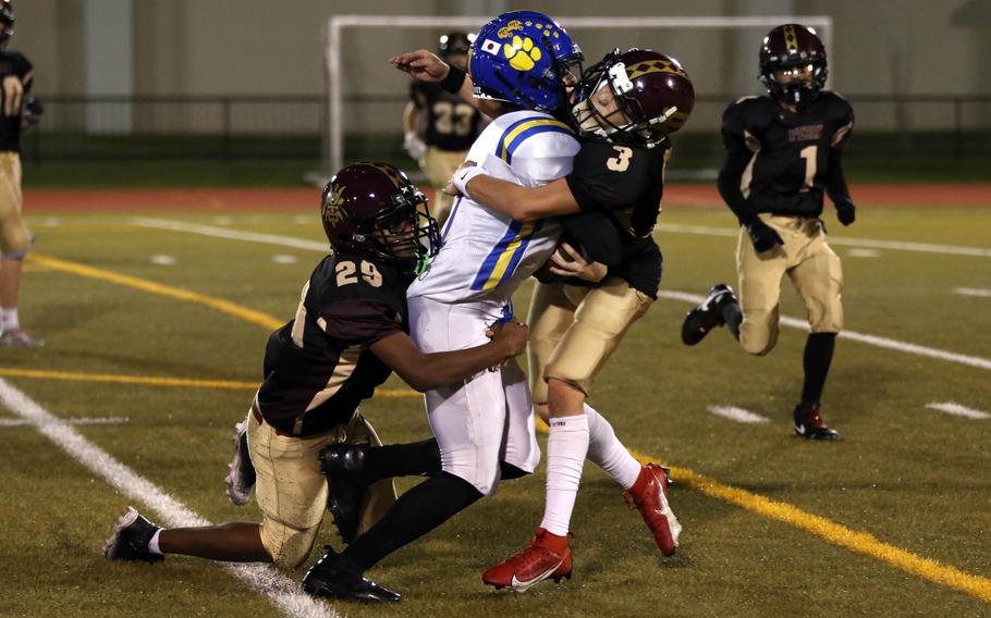 Travis Walker and Jerry Cordero tackle Jay Douglas.