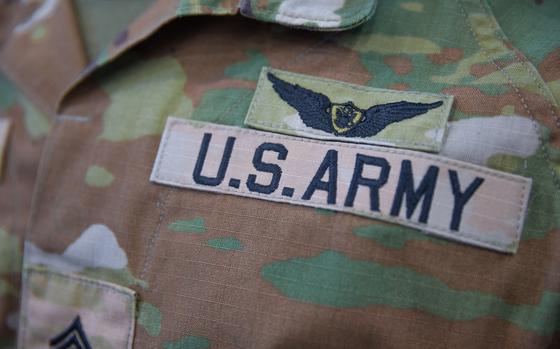 Close-up view of a camouflage military uniform with “U.S. Army” written on the chest.