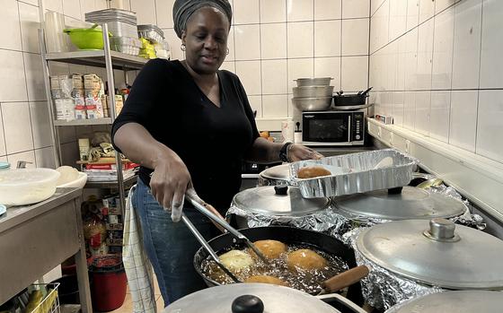 Christine Francis, owner of the Caribbean Grill in Grafenwoehr, Germany, flips her signature stuffed dumplings at the restaurant on Oct. 22, 2024.