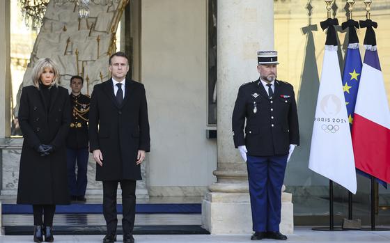 French President Emmanuel Macron and his wife Brigitte Macron stand for a minute of silence Monday, Dec. 23, 2024 at the Elysee Palace, in Paris, after Macron declared a day of national mourning for the lives lost when Cyclone Chido ripped through the Indian Ocean territory of Mayotte. (AP Photo/Thomas Padilla, Pool)