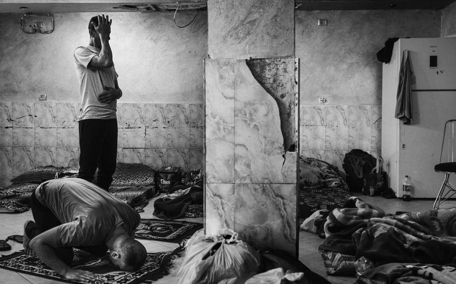 In the West Bank, Palestinian workers from Gaza pray on Oct. 16, 2023, as they wait to return home. 